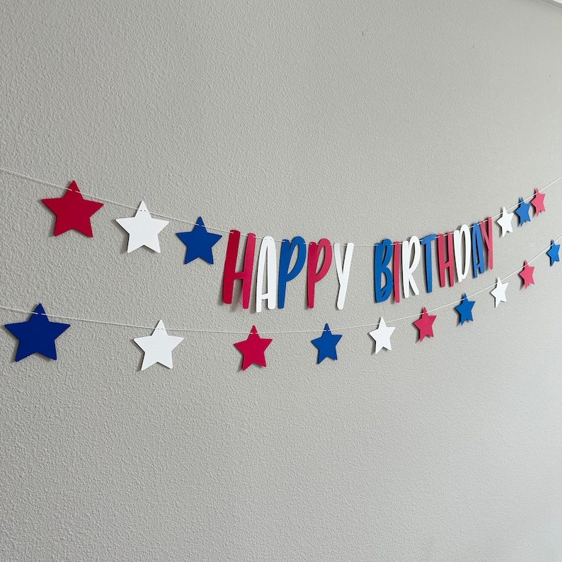May include: Red, white and blue paper star banner with the words "Happy Birthday" in red, white and blue letters.