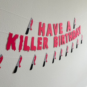 May include: A red and white paper banner with the words "Have a Killer Birthday" and small knife cutouts.