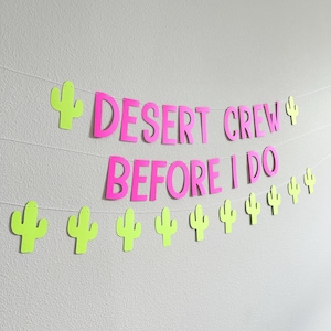 May include: A banner with the text "DESERT CREW BEFORE I DO" in bright pink letters. The banner is decorated with neon green cactus cutouts and strung on white string, perfect for a desert-themed party.