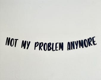 May include: Black and white banner with the text "NOT MY PROBLEM ANYMORE" printed on it.