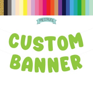 May include: Green custom banner with the words "CUSTOM BANNER" in large, bold letters. The banner is pre-strung and ready to hang.
