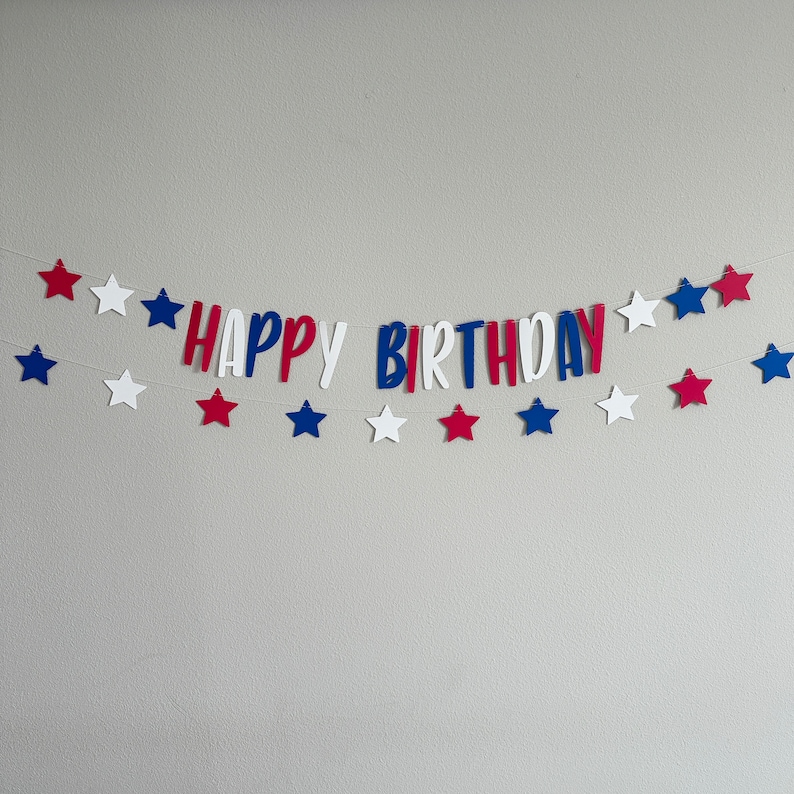 May include: Red, white and blue paper banner with the words "Happy Birthday" and stars.