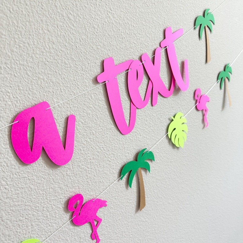 Puede incluir: Una guirnalda rosa con la palabra "text" en cursiva, adornada con palmeras, flamencos y una hoja. Una decoraci&oacute;n vibrante para una fiesta o evento con tem&aacute;tica tropical.