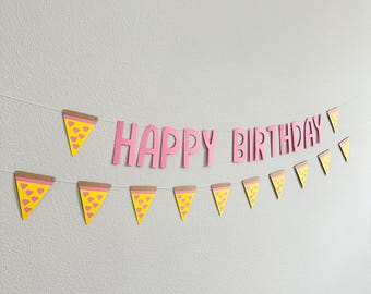 May include: A pink and yellow paper banner with the words "Happy Birthday" and pizza slice shapes.