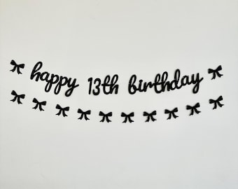 May include: Black and white happy 13th birthday banner with black bows.
