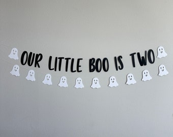 May include: A black and white banner with the text "OUR LITTLE BOO IS TWO" and white ghost cutouts.