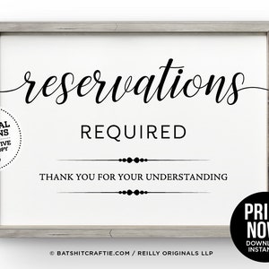 Può includere: Un cartello bianco con testo nero che recita "prenotazioni obbligatorie" e "grazie per la comprensione". Il cartello è incorniciato in una cornice di legno grigia.