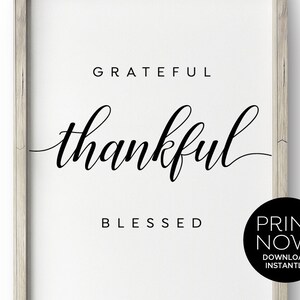 May include: A framed print featuring the words "Grateful, Thankful, Blessed" in black script and sans-serif font on a white background. A black circle with the words "Print Now! Download Instantly" is in the bottom right corner.