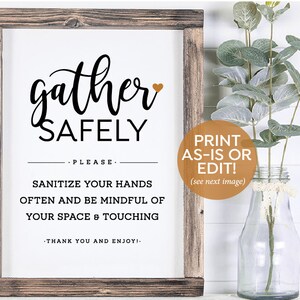Puede incluir: Un cartel blanco con un marco de madera marrón, que presenta el texto "Gather Safely" en letra cursiva negra con un pequeño corazón naranja. El cartel también incluye el texto "Please sanitize your hands often and be mindful of your space & touching. Thank you and enjoy!" en texto negro. El cartel está sentado sobre una superficie blanca con un jarrón de plantas verdes en el fondo.