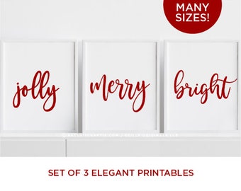 May include: Set of three printable Christmas signs featuring the words "jolly", "merry", and "bright" in red cursive font on a white background.