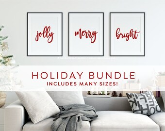 May include: Three framed prints with black frames and white mounts. The prints feature the words "jolly", "merry", and "bright" in red cursive lettering. The text "HOLIDAY BUNDLE INCLUDES MANY SIZES!" is displayed below the prints.