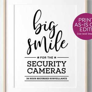 May include: Black and white sign with the text "big smile" and "FOR THE * SECURITY CAMERAS 24 HOUR RECORDED SURVEILLANCE".