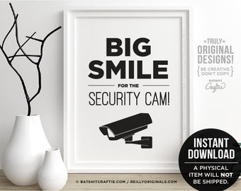Könnte beinhalten: Schwarzweißes druckbares Wandbild mit dem Text "BIG SMILE FOR THE SECURITY CAM!" und einer schwarzen Silhouette einer Überwachungskamera. Der Text "*TRULY* ORIGINAL DESIGNS! {BE CREATIVE. DON'T COPY.} BATSHIT Craftie" befindet sich in der oberen rechten Ecke. Der Text "BATSHITCRAFTIE.COM/REILLYORIGINALS.COM" befindet sich in der unteren linken Ecke. Der Text "INSTANT DOWNLOAD A PHYSICAL ITEM WILL NOT BE SHIPPED." befindet sich in der unteren rechten Ecke.