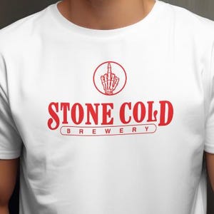 May include: White t-shirt with a red logo that says "STONE COLD BREWERY". The logo features a skeleton hand giving the middle finger.