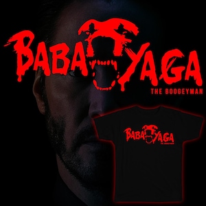 Puede incluir: Una camiseta negra con un gráfico rojo de una cabeza de lobo gruñendo y el texto "Baba Yaga The Boogeyman".