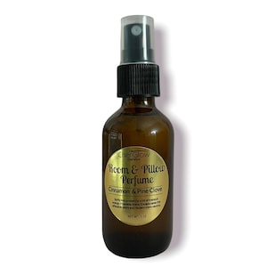 May include: A brown glass bottle with a gold label that reads "ChenGlow Cosmetics Room & Pillow Perfume Cinnamon & Pine Clove" and "NET WT: 2 OZ".