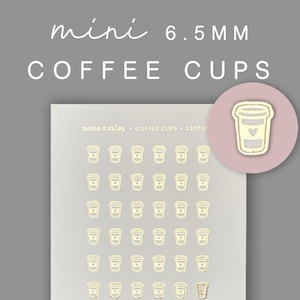 Op de afbeelding: Een vel met 6,5 mm gouden koffiebekerstickers. Het vel heeft 6 rijen met elk 7 stickers. De stickers zijn wit met een gouden rand en een klein hartje in elke beker. De tekst "notes & clips" en "COFFEE CUPS" staat op het vel gedrukt.