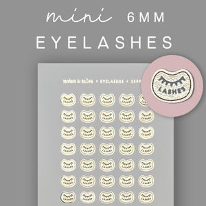 May include: A sheet of mini eyelashes stickers with the text "mini 6MM EYELASHES". The stickers are in a light beige color with a black outline and the word "LASHES" printed on them. A circular sticker with the word "LASHES" is also included.
