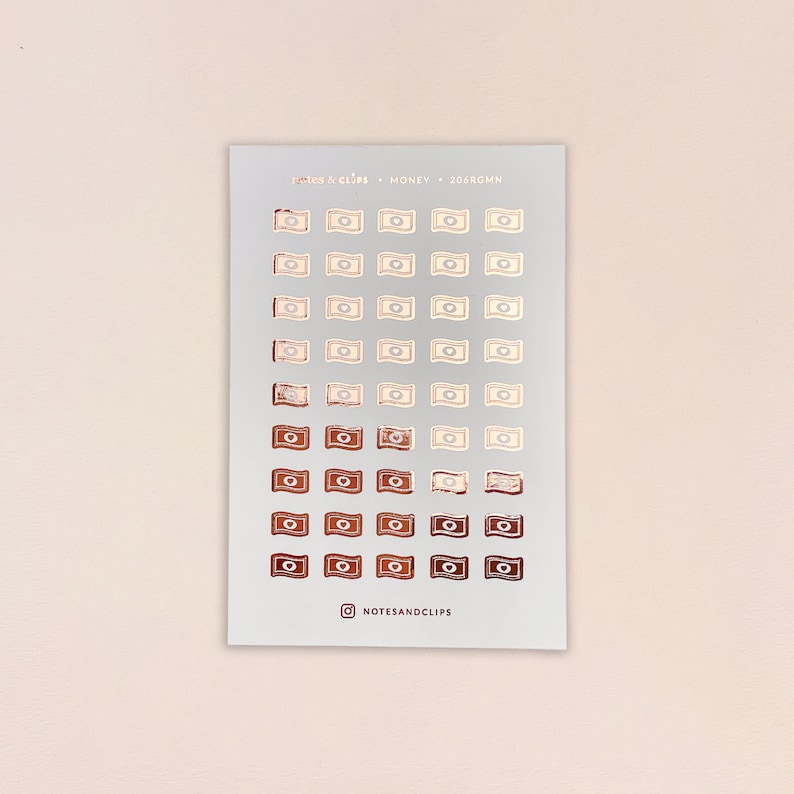 May include: A sheet of 50 rose gold foil stickers featuring a money bill design. The stickers are arranged in rows on a white background. The text "NOTES & CLIPS - MONEY - 206RGMM" is printed at the top of the sheet. The text "@NOTESANDCLIPS" is printed at the bottom of the sheet.