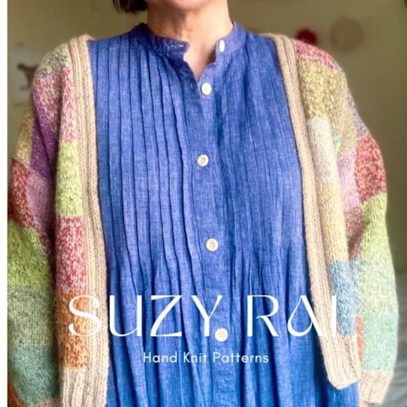 Op de afbeelding: Een veelkleurig gebreid vest met een beige rand wordt gedragen over een blauwe blousejurk. Het vest heeft pastelkleurige vierkanten in roze, groen, geel en paars. De tekst "SUZY RAI Hand Knit Patterns" is zichtbaar op het onderste deel van de afbeelding.