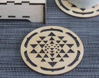 May include: A set of three wooden coasters featuring a geometric design. The coasters are made of light brown wood and have a laser-cut pattern. The coasters are perfect for protecting your furniture from heat and spills.