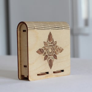 Wooden laser cut cigarette case with veneer walnut flower (inlay technique). Closes with sliding bolt hatch.