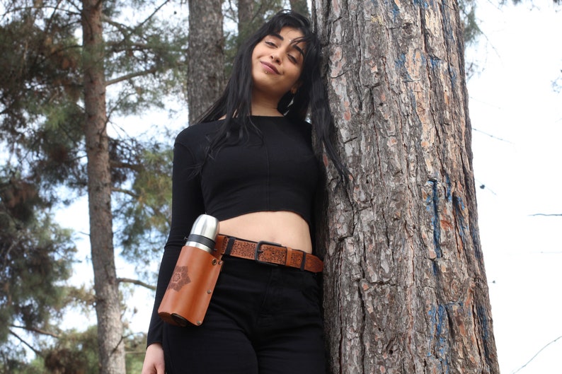 Model wearing Mandala Brown Leather Bottle Holder attached to her belt