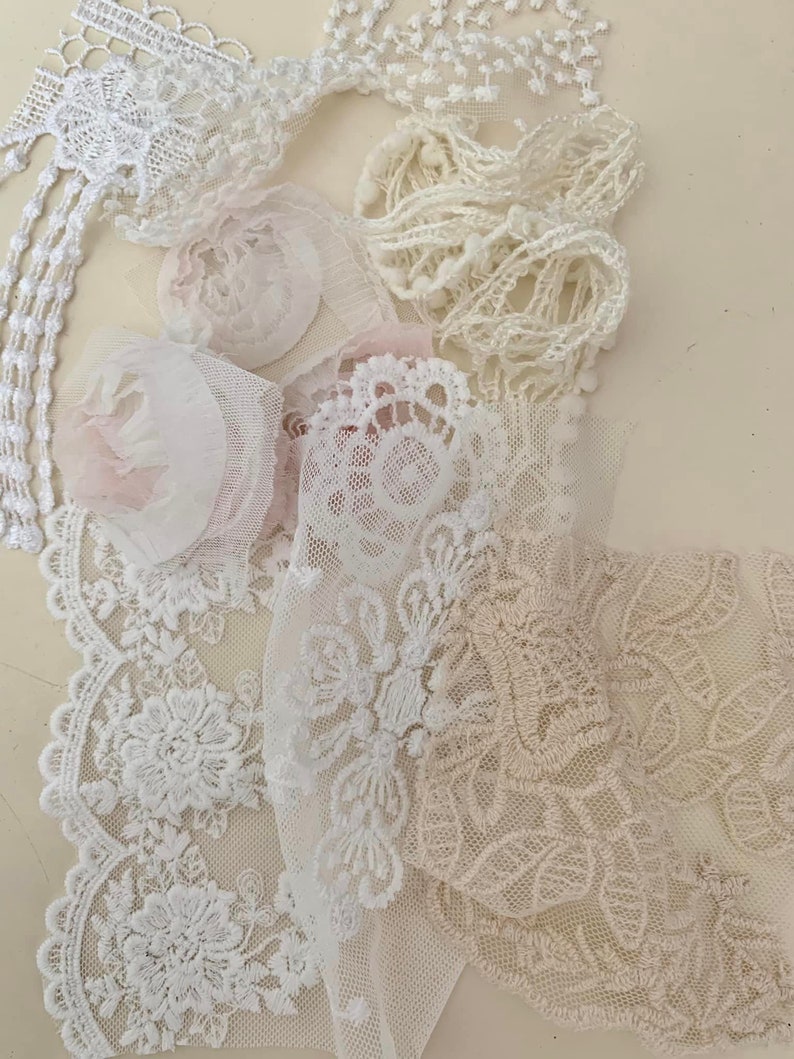 May include: Assortment of white and beige lace trims, including delicate floral patterns and scalloped edges. The lace is perfect for adding a touch of elegance to any project.