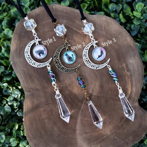 May include: Three crystal suncatchers with black cat and crescent moon charms. The charms are on a silver filigree crescent moon. The suncatchers are labeled "Style 1", "Style 2", and "Style 3".