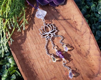 May include: A silver lotus flower pendant with a clear crystal at the top and dangling amethyst and citrine crystals.