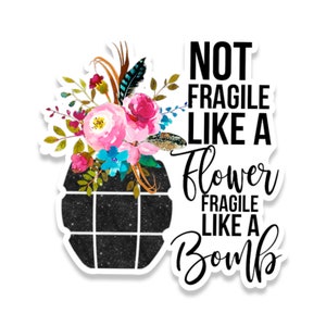 May include: A black and white graphic with a black grenade with a floral bouquet on top. The text reads "Not Fragile Like A Flower Fragile Like A Bomb."