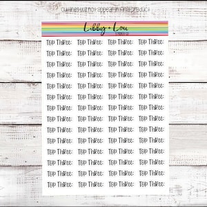 May include: A sheet of clear sticker paper with the phrase "Top Three" repeated multiple times in a handwritten font.