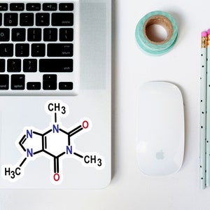 May include: A white sticker with a black and blue chemical structure diagram of caffeine. The diagram includes the chemical formula CH3, N, O, and H3C.