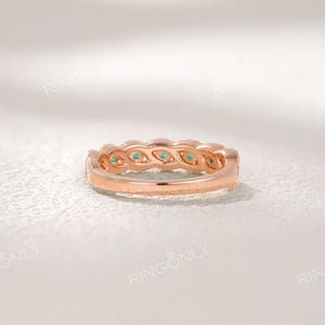 Op de afbeelding: Ros&eacute;gouden ring met een rij kleine, ronde, turquoise gekleurde edelstenen. De ring heeft een delicaat ontwerp met een getextureerde band en staat tegen een zachte, witte achtergrond. De merknaam "RINGONLY" is zichtbaar bovenaan.