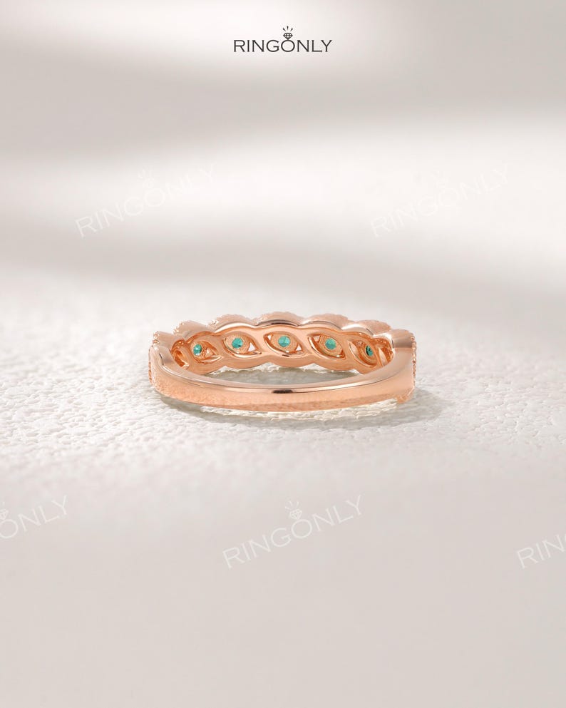 Op de afbeelding: Ros&eacute;gouden ring met een rij kleine, ronde, turquoise gekleurde edelstenen. De ring heeft een delicaat ontwerp met een getextureerde band en staat tegen een zachte, witte achtergrond. De merknaam "RINGONLY" is zichtbaar bovenaan.