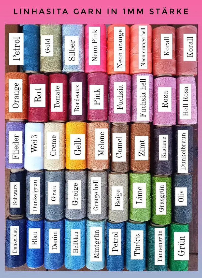Pu&ograve; includere: Una collezione di 36 bobine di filo in vari colori, tra cui blu, verde, rosso, arancione, giallo, marrone e viola. Le bobine sono etichettate con il nome del colore in tedesco. Il testo "LINHASITA GARN IN 1MM ST&Auml;RKE" &egrave; nella parte superiore dell'immagine.
