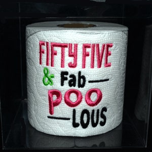May include: A white toilet paper roll with the text "Fifty Five & Fab-Poo-Lous" embroidered in pink, black, and green.