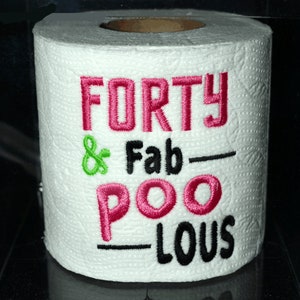 May include: A white toilet paper roll with pink and black embroidery that reads "FORTY & Fab-POO-LOUS".