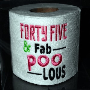 May include: White toilet paper roll with pink and green embroidery that reads "Forty Five & Fab-Poo-Lous".