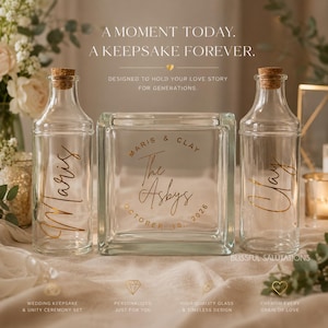 May include: Two clear glass bottles with cork stoppers and a central square glass block. The bottles feature the names Maris and Clay in gold script. The glass block displays the text The Asbys, Maris & Clay, and October 10, 2026 in gold.