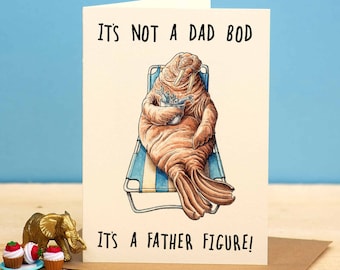Op de afbeelding: Een kaart met een cartoon-walrus die op een strandstoel zit. De kaart staat: "Het is geen vaderslijf, het is een vaderfiguur!"