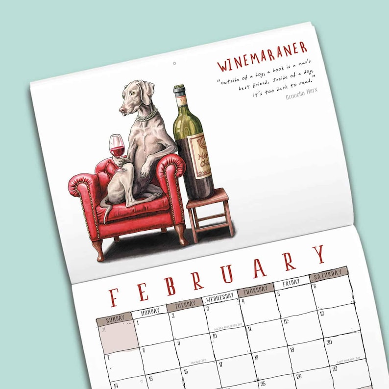 May include: A wall calendar page for February featuring a Weimaraner dog wearing a pearl necklace, sitting in a red tufted armchair holding a wine glass next to a wine bottle on a stool. The text reads WINEMARANER and a quote by Groucho Marx.