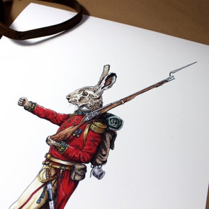 May include: A brown rabbit wearing a red military uniform with a brown backpack and a rifle. The rabbit is holding the rifle with its right paw and has its left paw raised in the air.