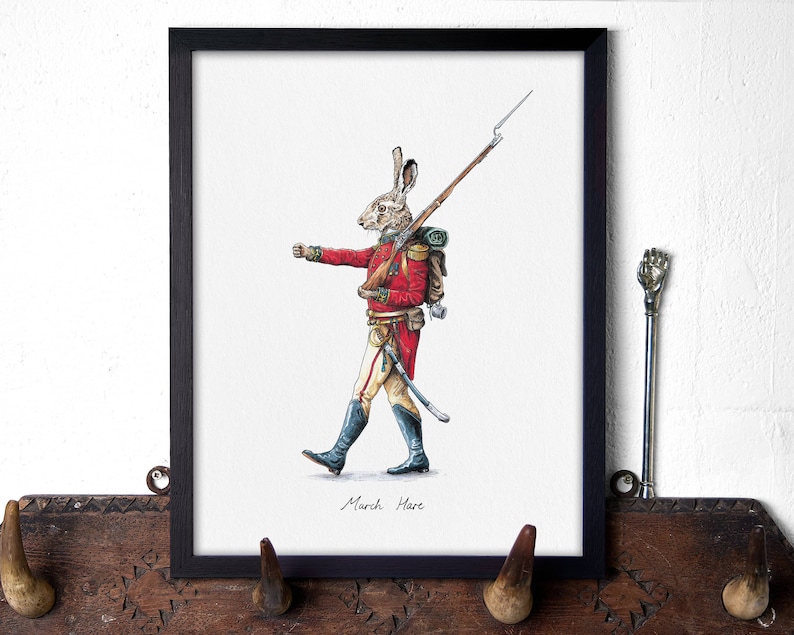 May include: A framed illustration of a rabbit dressed as a soldier, holding a rifle and marching forward. The illustration is in a black frame and has the text "March Hare" at the bottom.