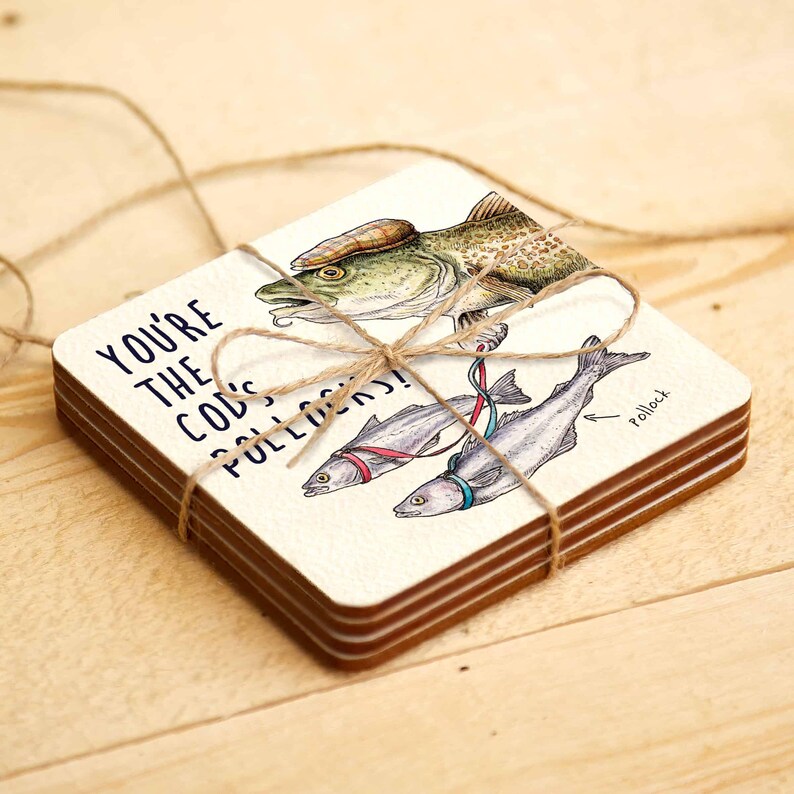 May include: Set of four coasters featuring a humorous illustration of a cod fish wearing a hat and pulling two smaller fish with a string. The text on the coaster reads "You're the cod's bolloxs!"