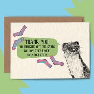 May include: A greeting card with a cartoon illustration of a weasel and several socks. The card has the text "THANK YOU FOR CHECKING OUT OUR CARDS! WE HOPE THEY KNOCK YOUR SOCKS OFF!" in a green speech bubble.