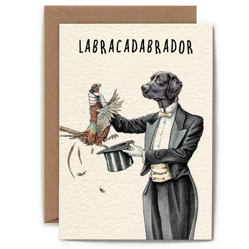 May include: Greeting card with a black Labrador Retriever in a tuxedo, holding a pheasant and a top hat. The text "LABRACADABRADOR" is printed at the top. The card is inside a brown envelope.