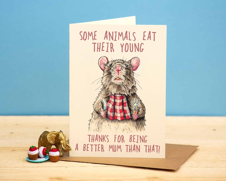 May include: A humorous greeting card featuring a cartoon rat holding a knife and fork, with the text "Some animals eat their young. Thanks for being a better mum than that!"