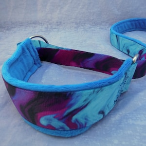 Könnte beinhalten: Ein blaues und violettes Marmor-Hundehalsband mit weichem blauen Fleece-Futter. Das Halsband hat einen silbernen D-Ring aus Metall.