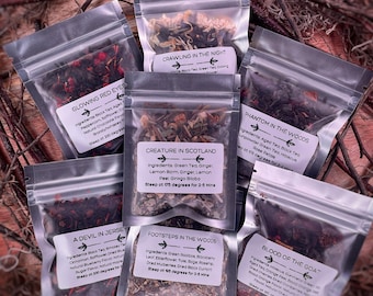 Può includere: Assortimento di piccoli sacchetti di plastica trasparente riempiti di miscele di tè sfuso. Ogni sacchetto ha un'etichetta con un nome unico e un elenco di ingredienti. I nomi includono "Glowing Red Eyes", "Crawling in the Night", "Creature in Scotland", "Phantom in the Woods", "A Devil in Jersey", "Footsteps in the Woods" e "Blood of the Goat".